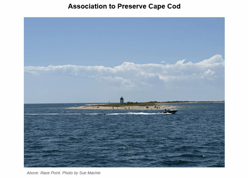 Aerial view of Race Point lighthouse and sandy beach peninsula surrounded by blue ocean waters under a partly cloudy sky, with small groups of beachgoers visible on the shore